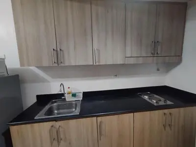 a kitchen with a sink and wooden cabinets at Shore D 1422 in Manila