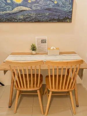 a table with two chairs and a painting at Cozy Condo in Mandaluyong with Balcony, Pool &Netflix in Manila