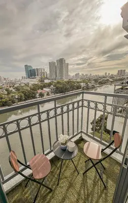 a balcony with two chairs and a table with a view at Cozy Condo in Mandaluyong with Balcony, Pool &Netflix in Manila