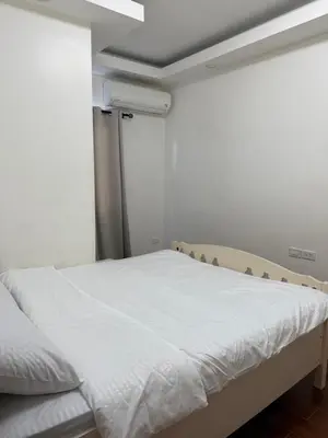 a bedroom with a bed with white sheets at 2 AC in 1 Room JCAL Building Near Manila Airports MOA OKADA in Manila