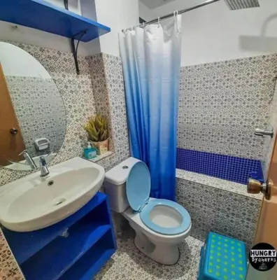 a bathroom with a blue toilet and a sink at Staycation in Valley Golf near Antipolo in Cainta