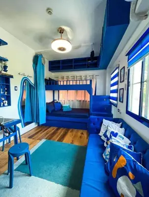 a living room with a blue couch and a slide at Staycation in Valley Golf near Antipolo in Cainta