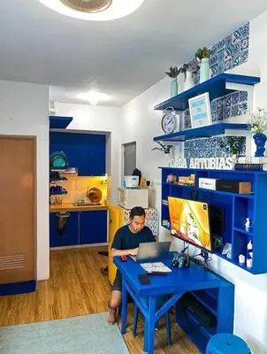 a man sitting at a blue desk with a laptop at Valley Mansions Staycation near Taytay in Cainta