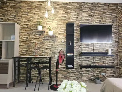 a brick wall with a table and a television at Valley Golf Condominium Staycation in Cainta