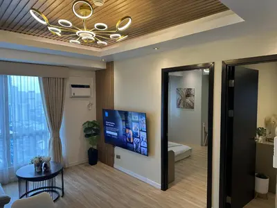 a living room with a tv on the wall at Amazing Sunrise View 2 Bed Room, QLED 65-Inch Samsung TV, Disney & Max, Max 5 Adult and 2 kids in Manila