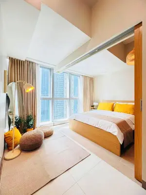 a bedroom with a bed and a large window at Andi and Frances Place at BGC in Manila