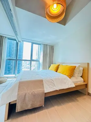 a bedroom with a large bed with a large window at Andi and Frances Place at BGC in Manila