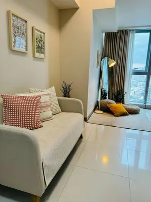 a living room with a couch and a large window at Andi and Frances Place at BGC in Manila