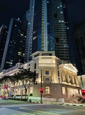 a building on the corner of a street with tall buildings at Andi and Frances Place at BGC in Manila