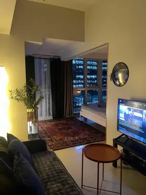 a living room with a couch and a television at Cozy place in Uptown BGC near Malls and clubs in Manila