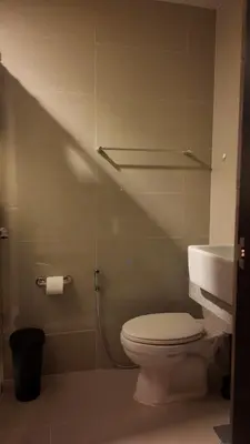 a bathroom with a toilet and a sink at Cozy place in Uptown BGC near Malls and clubs in Manila