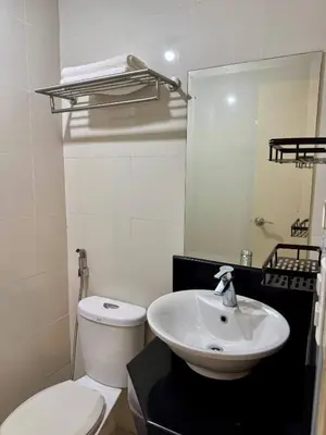 a bathroom with a sink and a toilet and a mirror at Newport Stay Walk to NAIA T3 in Manila