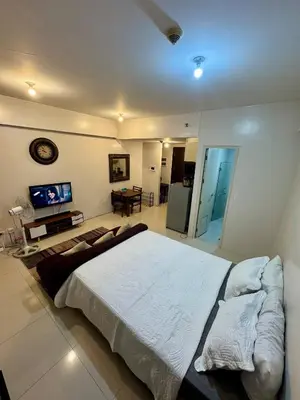 a large bedroom with a large bed and a television at Newport Stay Walk to NAIA T3 in Manila