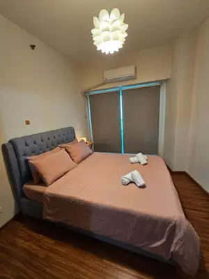 a bedroom with a bed with two towels on it at Amorsolo Tower Makati in Manila