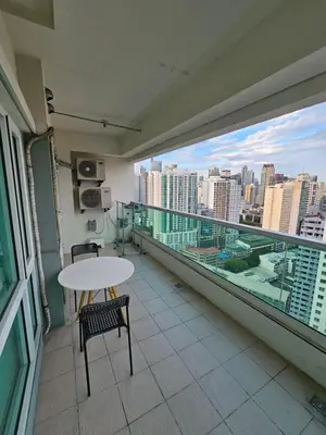 a balcony with a table and chairs and a view of the city at Amorsolo Tower Makati in Manila