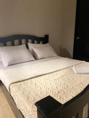 a large bed with white sheets and pillows at 3ms and jacob havens in Manila