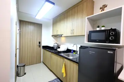 a kitchen with a black refrigerator and a sink at Modern Living 6 - MOA Pasay with Wifi and Netflix in Manila
