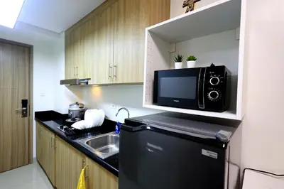 a kitchen with a microwave on top of a refrigerator at Modern Living 6 - MOA Pasay with Wifi and Netflix in Manila