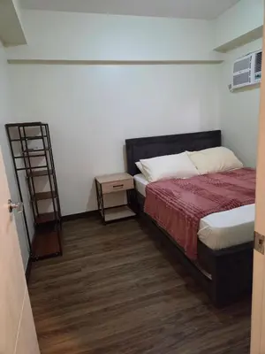 a small bedroom with a bed and a book shelf at Minimalist stay in Satori Residences Pasig City in Manila