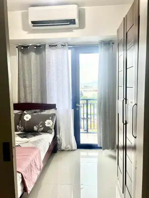 a small bedroom with a bed and a window at V&G Staycation in Manila