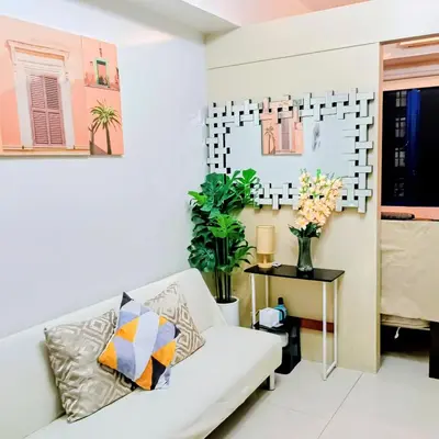 a living room with a white couch and a table at Grace era Staycation in Manila
