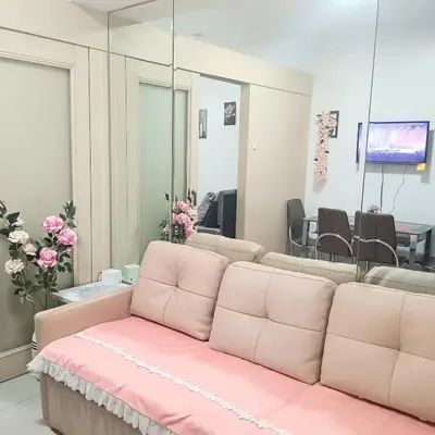 a salon with a pink couch in front of a mirror at Grace era Staycation in Manila