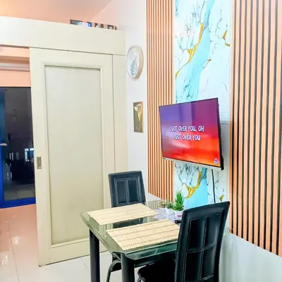 an office with a table and a tv on a wall at Grace era Staycation in Manila