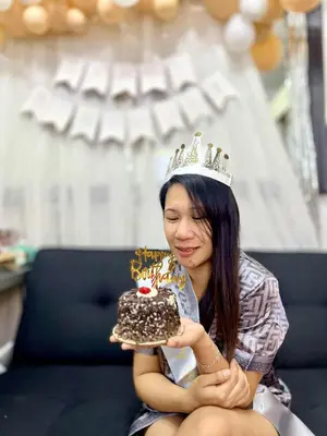 a woman wearing a crown holding a chocolate cake at Eden Era staycation in Manila