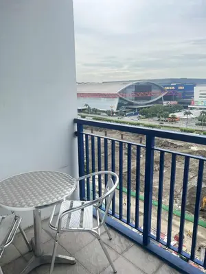a balcony with a table and chairs and a view of a stadium at Yoona era Staycation in Manila