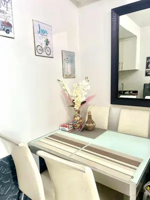 a dining room table with a mirror and a vase of flowers at Yoona era Staycation in Manila