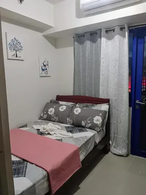 a small bedroom with a bed and a window at Yoona era Staycation in Manila