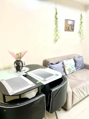 a living room with a table and a couch at Rhon's Staycation in Manila
