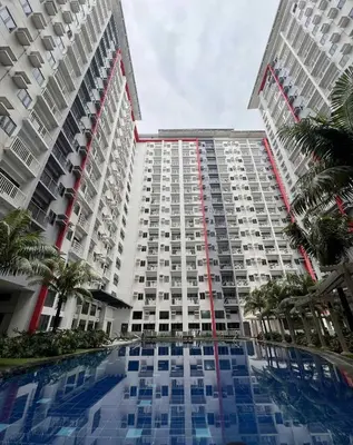 a large building with a pool in front of it at Bloom Residence by SMDC in Manila