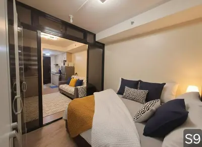 a bedroom with a bed and a sliding glass door at S-Line - Your place, your comfort! in Manila
