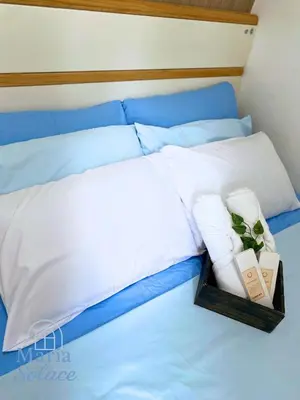 a bed with white pillows and a tray with towels at Maria Solace in Manila