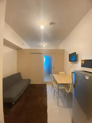a living room with a couch and a table at Light Residence Condo with Balcony and Pool View in Manila