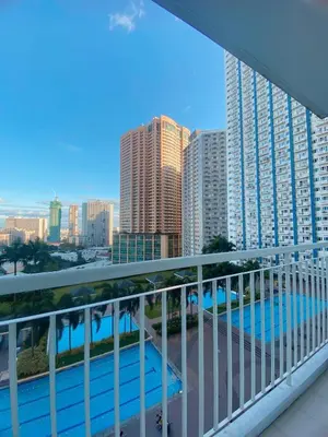 a balcony with a view of the city and buildings at Light Residence Condo with Balcony and Pool View in Manila