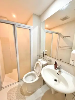 a white bathroom with a toilet and a sink at Playa Delea Minimalist Azure 1BR Pool Beach Staycation in Manila
