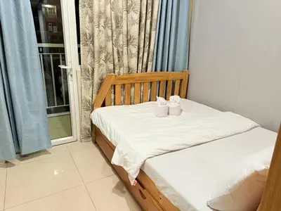 a bedroom with a bed with two white shoes on it at Premiere Haven MOA Staycation in Manila