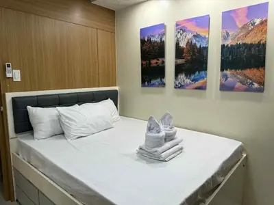 a bedroom with a bed with towels on it at Premiere Haven MOA Staycation in Manila