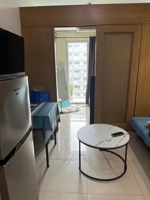 a living room with a table and a refrigerator at MOA Staycation Condotel PASAY in Manila