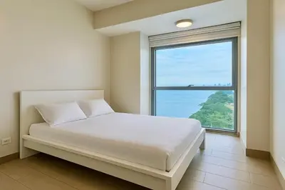 a bedroom with a bed and a large window at Bayshore 2 ManilaBay Seaview 3 in Manila