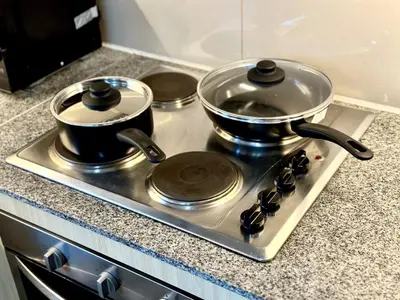 two pots and pans sitting on top of a stove at Bayshore 2 ManilaBay Seaview 3 in Manila