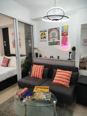 a living room with a couch and a glass table at Azure Staycation with Pool View, Wifi and Netflix in Manila