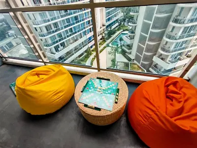 a room with two ottomans and two chairs and a window at Azure Staycation with Pool View, Wifi and Netflix in Manila