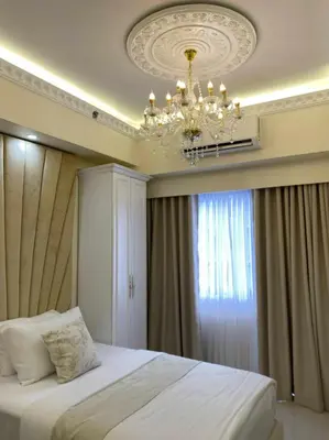 a bedroom with a chandelier and a large bed at Chateau Lumiere Staycation at MOA in Manila