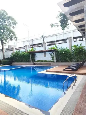 a large swimming pool with blue water in a building at Studio City Staycation in Alabang in Manila