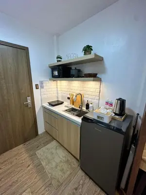 a small kitchen with a stove and a sink at Studio City Staycation in Alabang in Manila