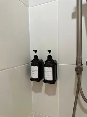 two bottles of soap sitting on a tiled wall at Studio City Staycation in Alabang in Manila