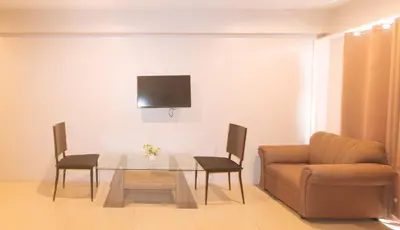 a living room with a glass table and a couch at RedDoorz at Regina Hometel J Victor in Manila